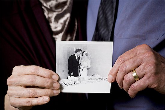 Portrait of an elderly couple showing a photograph Stock Photo - Premium Royalty-Free, Image code: 640-02767071