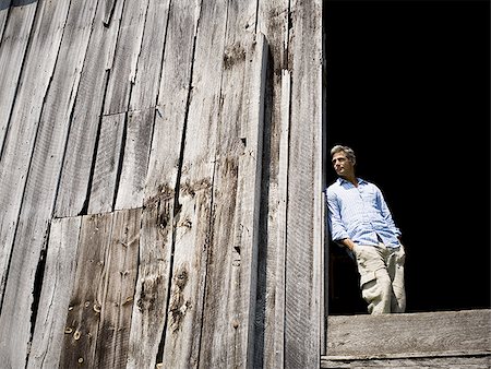 Low angle view of a man leaning against a wooden wall Foto de stock - Sin royalties Premium, Código: 640-02767110