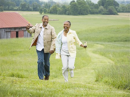 Senior woman and a senior man running in a field Stock Photo - Premium Royalty-Free, Code: 640-02767167