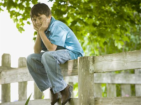 Portrait of a boy sitting on a wooden fence Stock Photo - Premium Royalty-Free, Code: 640-02767202