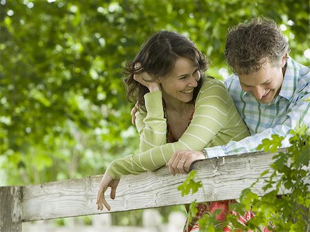 man and a woman leaning on a wooden fence Stock Photo - Premium Royalty-Free, Code: 640-02767215