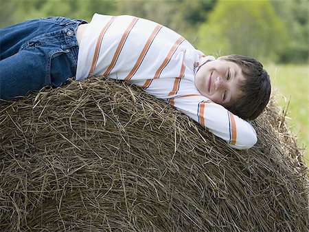 simsearch:614-07146362,k - Portrait of a boy lying on a hay bale Fotografie stock - Premium Royalty-Free, Codice: 640-02767226