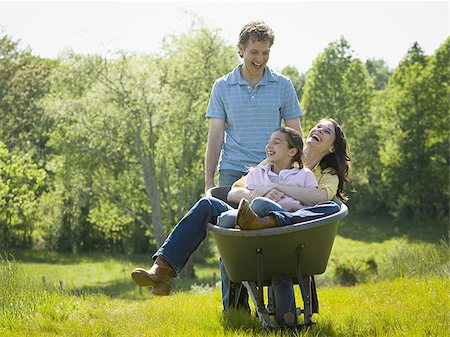 man pushing his daughter and his wife in a wheelbarrow Stock Photo - Premium Royalty-Free, Code: 640-02767294