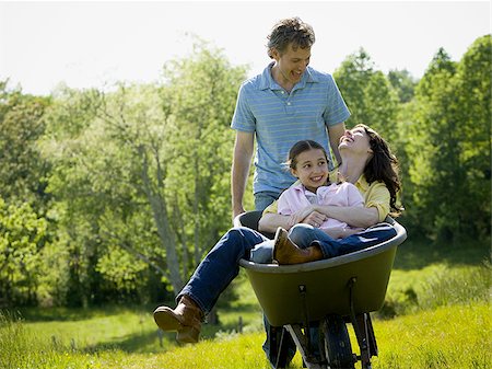 man pushing his daughter and his wife in a wheelbarrow Stock Photo - Premium Royalty-Free, Code: 640-02767295