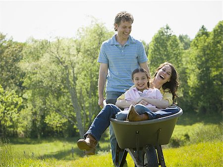 man pushing his daughter and his wife in a wheelbarrow Stock Photo - Premium Royalty-Free, Code: 640-02767296