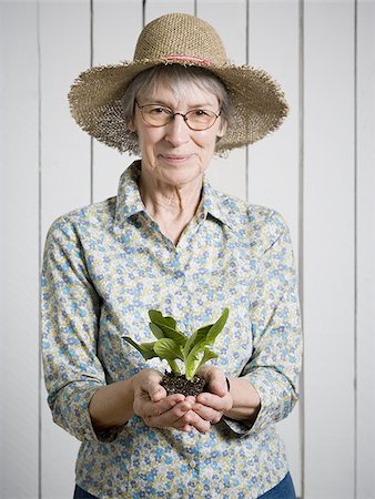 Portrait of an elderly woman holding a plant Stock Photo - Premium Royalty-Free, Code: 640-02767398