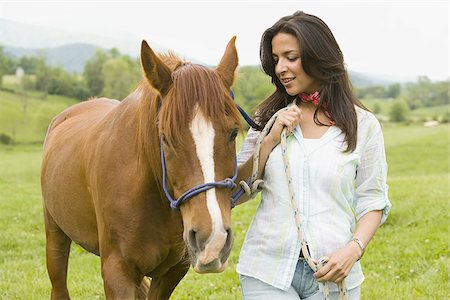 Portrait of a woman holding the reins of a horse Stock Photo - Premium Royalty-Free, Code: 640-02767474