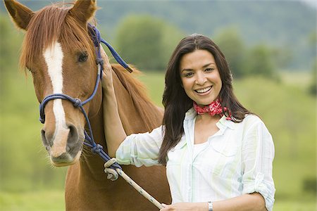 Portrait of a woman holding the reins of a horse Stock Photo - Premium Royalty-Free, Code: 640-02767471