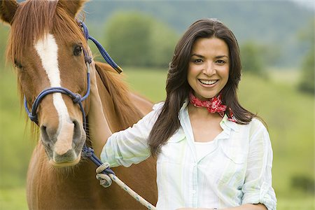 Portrait of a woman holding the reins of a horse Stock Photo - Premium Royalty-Free, Code: 640-02767472