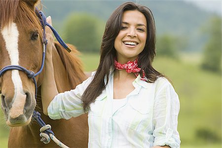 Portrait of a woman holding the reins of a horse Stock Photo - Premium Royalty-Free, Code: 640-02767473