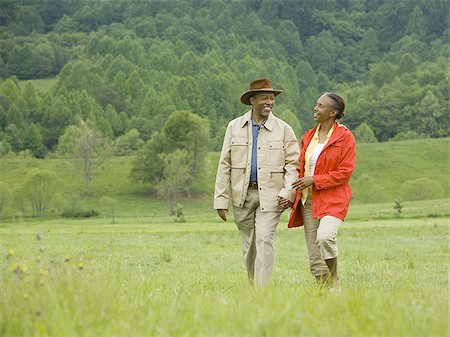 Portrait of a senior man and a senior woman walking in a field Stock Photo - Premium Royalty-Free, Code: 640-02767524