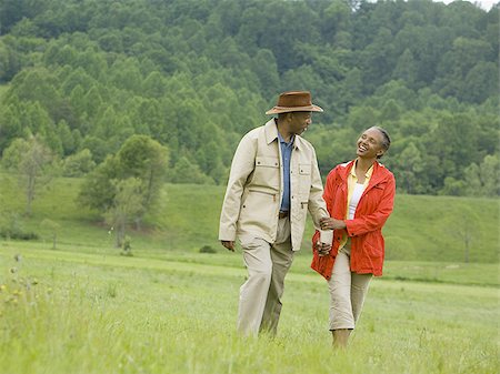 Senior man and a senior woman walking in a field Stock Photo - Premium Royalty-Free, Code: 640-02767529