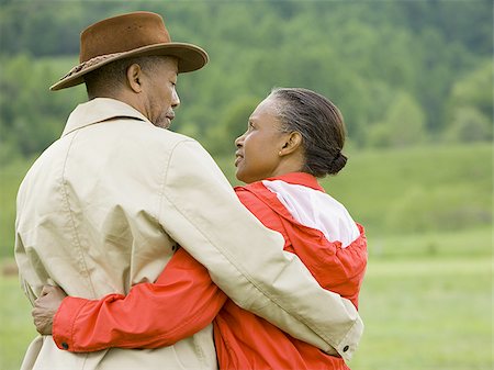 Rear view of a senior man and a senior woman with their arms around each other Stock Photo - Premium Royalty-Free, Code: 640-02767522
