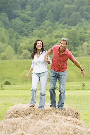 simsearch:640-03265364,k - Portrait of a man and a woman running on hay bales Stock Photo - Premium Royalty-Free, Code: 640-02767547