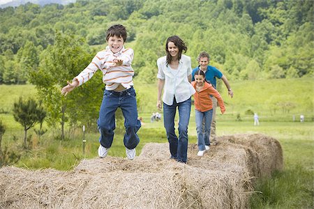 woman and a man standing with their children on hay bales Stock Photo - Premium Royalty-Free, Code: 640-02767579