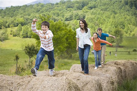 fun kid 10 - woman and a man standing with their children on hay bales Stock Photo - Premium Royalty-Free, Code: 640-02767580