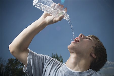 poured on her head - Close-up of a teenage boy drinking water from a water bottle Stock Photo - Premium Royalty-Free, Code: 640-02767751