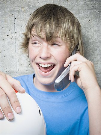 portrait of boy sitting on skateboard - Portrait of a teenage boy using a mobile phone Stock Photo - Premium Royalty-Free, Code: 640-02767761