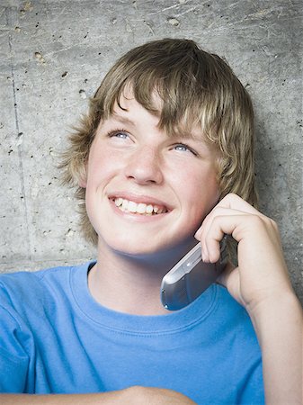 portrait of boy sitting on skateboard - Portrait of a teenage boy using a mobile phone Stock Photo - Premium Royalty-Free, Code: 640-02767762