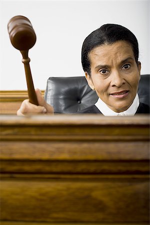 Portrait of a female judge holding a gavel and smiling Stock Photo - Premium Royalty-Free, Code: 640-02767833