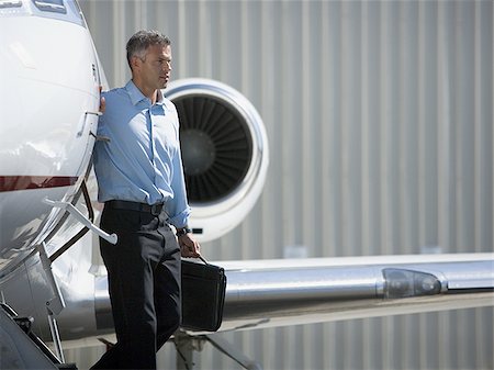 Profile of a businessman exiting an airplane Stock Photo - Premium Royalty-Free, Code: 640-02767926