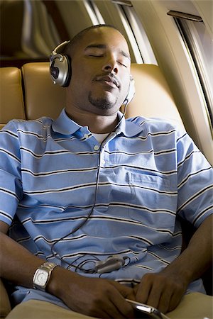 simsearch:640-01350948,k - A man listening to music on headphones in an airplane Stock Photo - Premium Royalty-Free, Code: 640-02767960