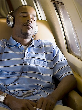 simsearch:640-02767934,k - Un homme, écouter de la musique sur le casque dans un avion Photographie de stock - Premium Libres de Droits, Code: 640-02767961