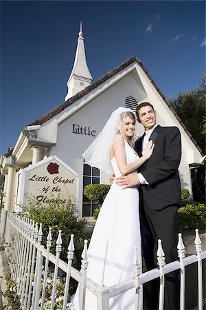 simsearch:640-01363514,k - Portrait d'un couple de jeunes mariés, debout devant une chapelle et souriant Photographie de stock - Premium Libres de Droits, Code: 640-02768006