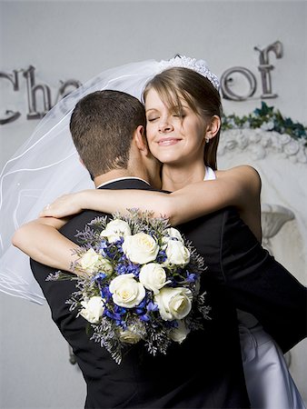 Close-up of a newlywed couple embracing each other and smiling Stock Photo - Premium Royalty-Free, Code: 640-02768014