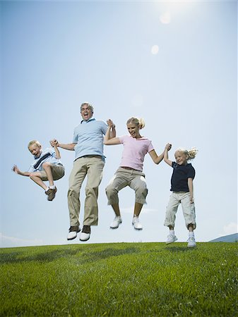 sun care - Low angle view of parents and their two children jumping Stock Photo - Premium Royalty-Free, Code: 640-02768025