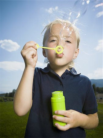 Close-up of a girl blowing bubbles with a bubble wand Stock Photo - Premium Royalty-Free, Code: 640-02768043