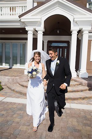 Newlywed couple walking down the steps in front of a building Stock Photo - Premium Royalty-Free, Code: 640-02768106