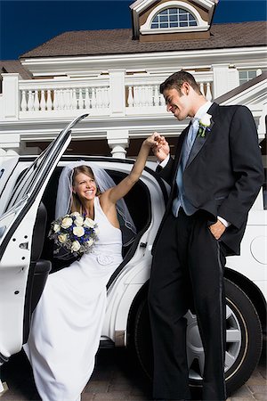 Groom kissing his bride's hand and getting out of a car Stock Photo - Premium Royalty-Free, Code: 640-02768117