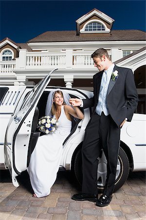 Young man holding his bride's hand and exiting a car Stock Photo - Premium Royalty-Free, Code: 640-02768113