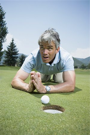 simsearch:640-01356786,k - Close-up of a man kneeling in front of a golf ball near a hole and praying Foto de stock - Sin royalties Premium, Código: 640-02768128