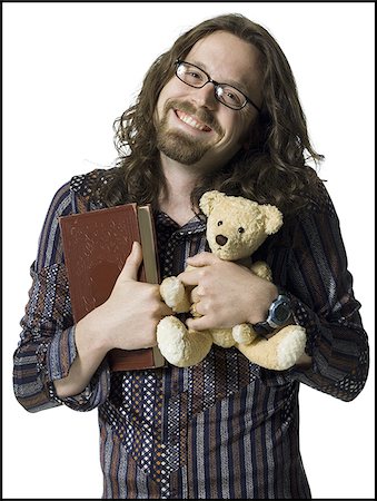 Portrait of a young man holding a book and a teddy bear Stock Photo - Premium Royalty-Free, Code: 640-02768156