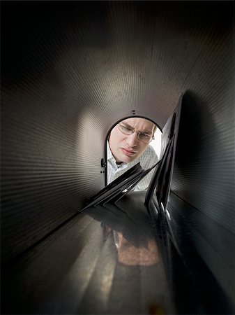 Close-up of a young man looking into a mailbox Stock Photo - Premium Royalty-Free, Code: 640-02768384