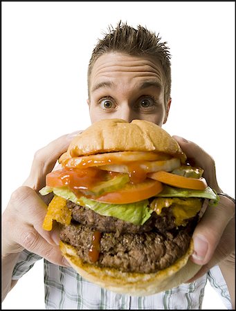 simsearch:640-01356052,k - Portrait d'un jeune homme tenant un hamburger Photographie de stock - Premium Libres de Droits, Code: 640-02768394