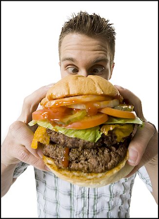 simsearch:640-01356052,k - Gros plan d'un jeune homme tenant un hamburger Photographie de stock - Premium Libres de Droits, Code: 640-02768395