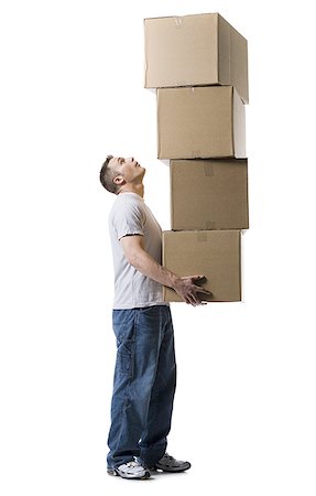 Profile of a young man holding a stack of cardboard boxes Stock Photo - Premium Royalty-Free, Code: 640-02768396
