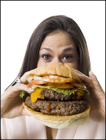 Close-up of a young woman holding a hamburger Stock Photo - Premium Royalty-Free, Code: 640-02768392