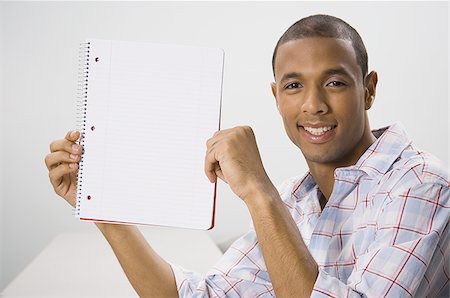 simsearch:640-02768435,k - African American male student holding blank workbook Fotografie stock - Premium Royalty-Free, Codice: 640-02768432