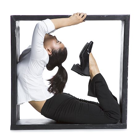 Female contortionist businesswoman inside the box Stock Photo - Premium Royalty-Free, Code: 640-02768593