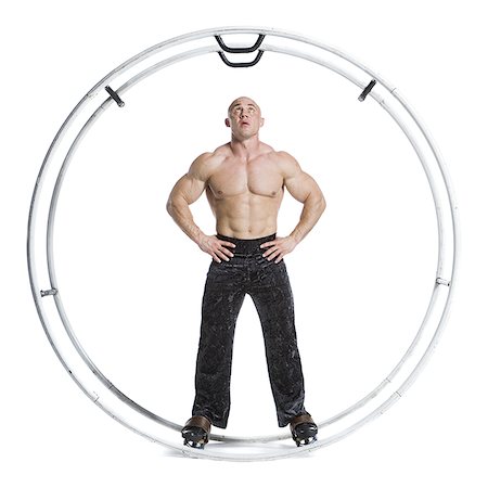 Male bodybuilder posing in German wheel Stock Photo - Premium Royalty-Free, Code: 640-02768635