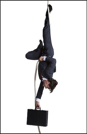 simsearch:640-02768663,k - Businessman with briefcase dangling upside down from a rope Foto de stock - Sin royalties Premium, Código: 640-02768673