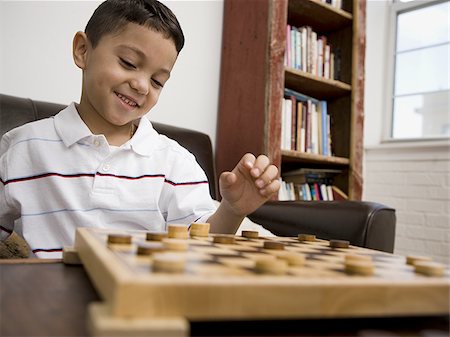 Young boy playing checkers Stock Photo - Premium Royalty-Free, Code: 640-02768748