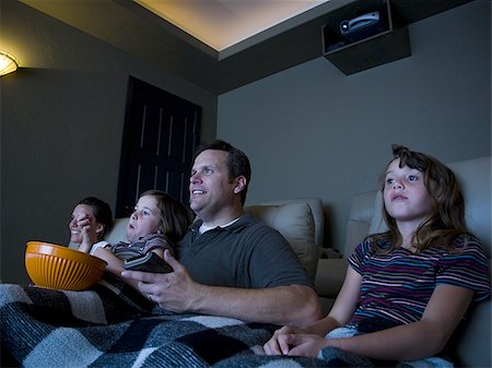 Father and daughters watching movie in home theater Foto de stock - Sin royalties Premium, Código: 640-02769028