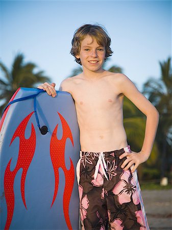 Boy on beach with boogie board Stock Photo - Premium Royalty-Free, Code: 640-02769197