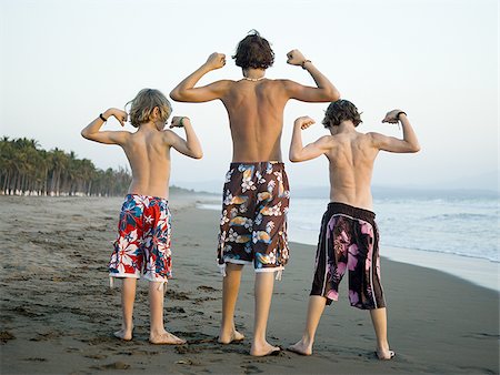 flexing muscles at beach - Three boys playing on beach Stock Photo - Premium Royalty-Free, Code: 640-02769219