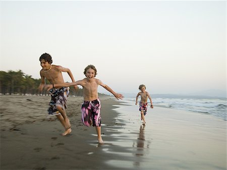 friends race - Three boys playing on beach Stock Photo - Premium Royalty-Free, Code: 640-02769230